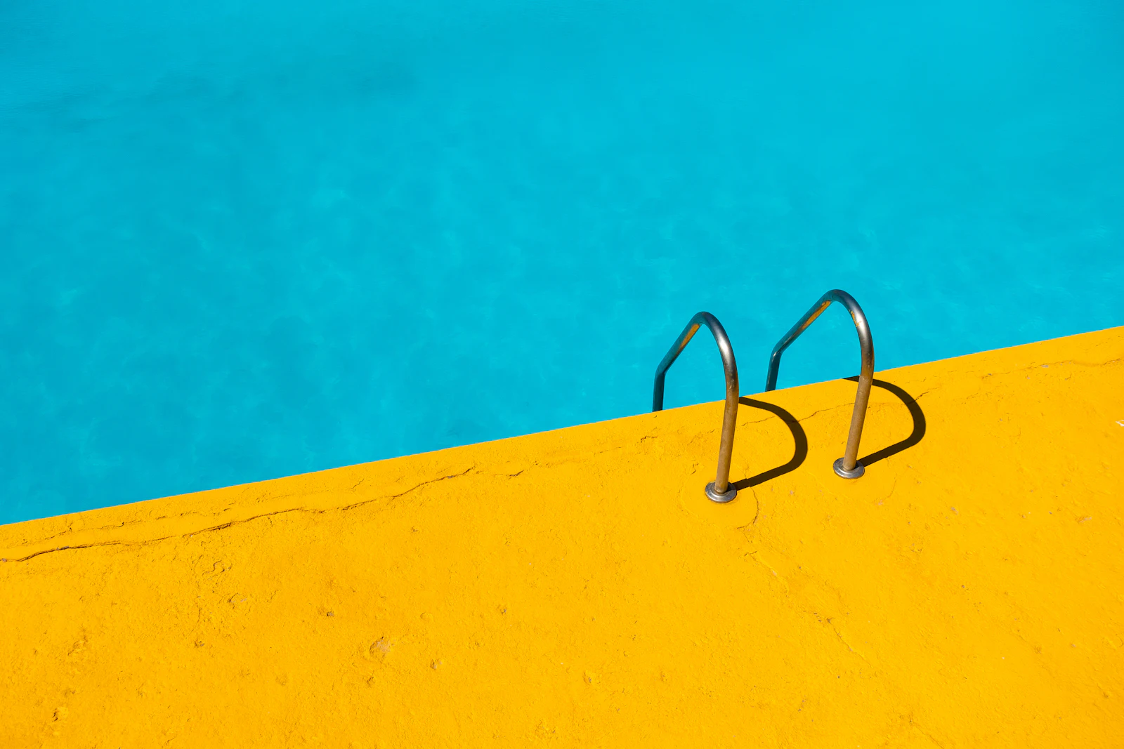 Turquoise swimming pool with a steel ladder
